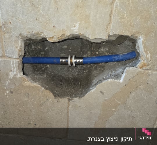 צינור כחול בקיר עם חיבורי אינסטלציה